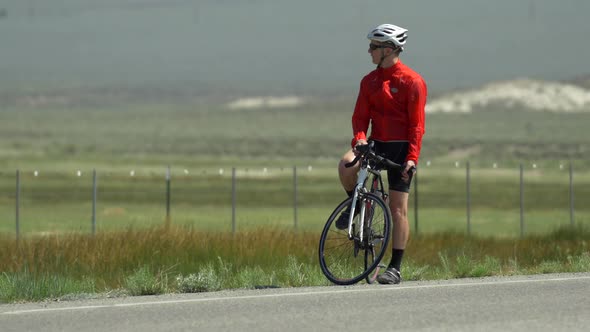 A man road biking on a scenic road.