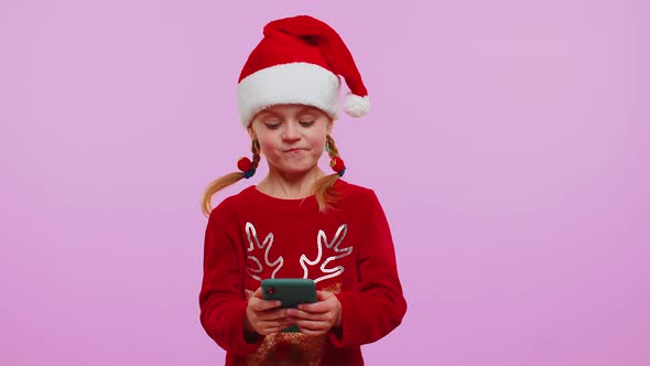 Girl in Christmas Sweater Hat Using Mobile Phone Typing New Post on Web Shopping Online Browsing