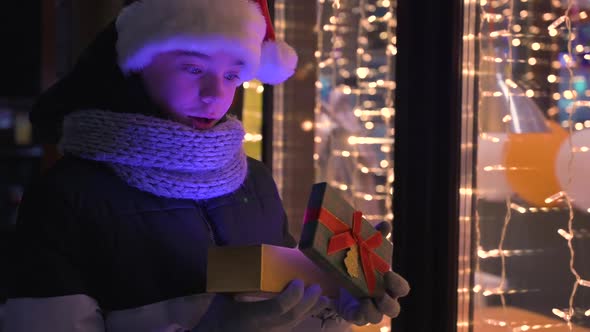 Boy in Santas Hat with Gifts Box Looking and Dreaming