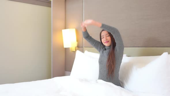 Asian woman relax on bed in bedroom interior