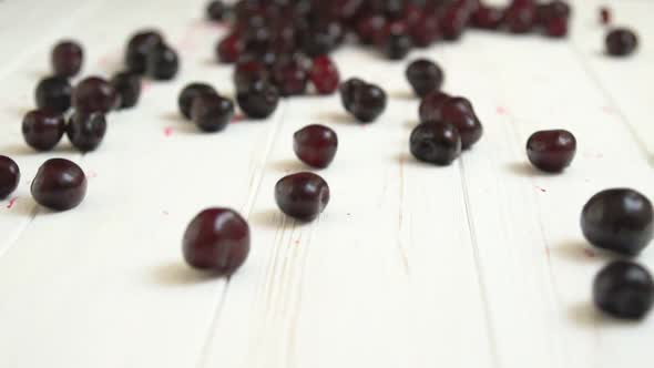 Ripe Cherries Rolling Across a Wooden Table