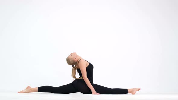 A woman doing yoga exercises on a white background at home.