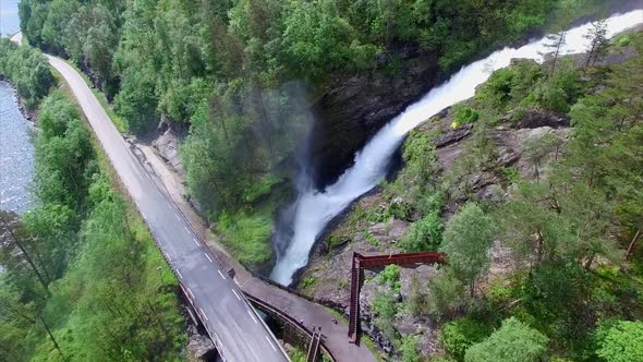 Massive Svandalsfossen waterfall passing below the road in Norway