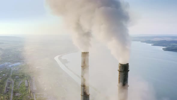 Aerial view of coal power plant high pipes with black smoke moving up polluting atmosphere alt
