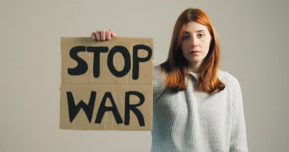 Young Girl Raises Up the Billboard That Says Stop War During the Protest