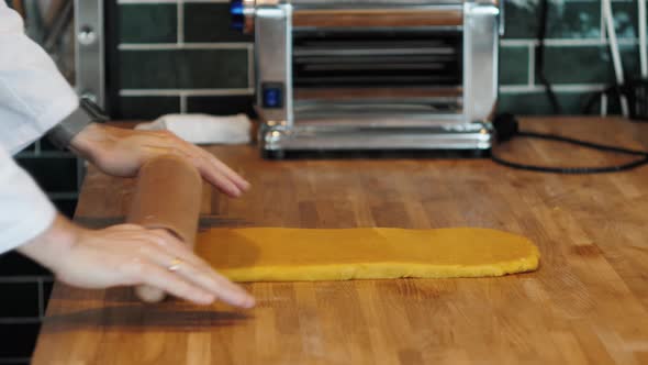 Chef Making Spaghetti Noodles and Lasagne Dough with Pasta Machine on Kitchen Table with Some