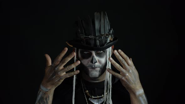 Scary Guy in Carnival Costume of Halloween Skeleton Against Black Background. Man Skull Makeup