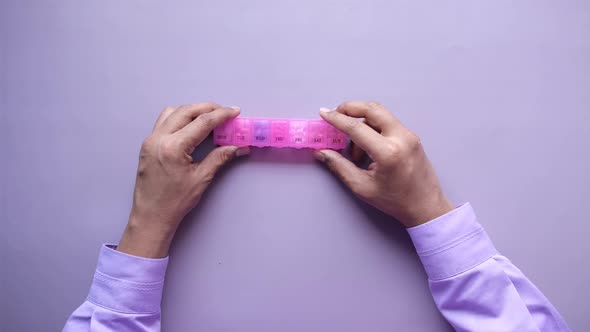 Man's Hands Taking Medicine From a Pill Box