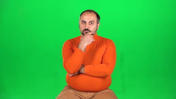 Full Caucasian Man Looking at Camera with Smile, Listens Attentively Stroking a Beard. Green Screen