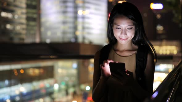 Woman looking at mobile phone in city 