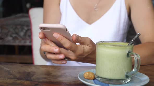 Close Up of Female Texting in a Coffee Place