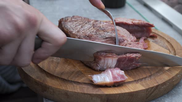 Cutting Slicing Medium Rare Meat Grilled Barbecue Steak with Knife