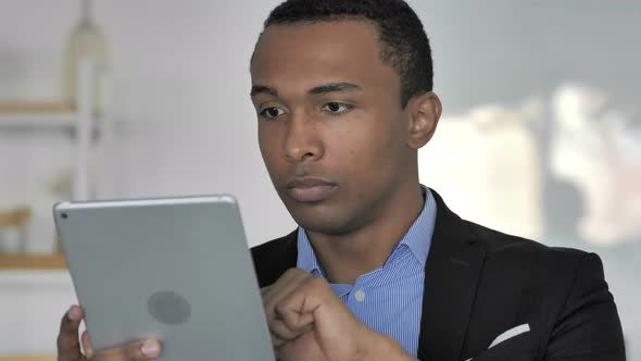 Close Up Of Casual Afro-American Businessman Browsing Internet on Tablet