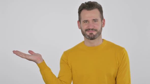 Portrait of Middle Aged Man Holding Product on Hand Advertising Gesture