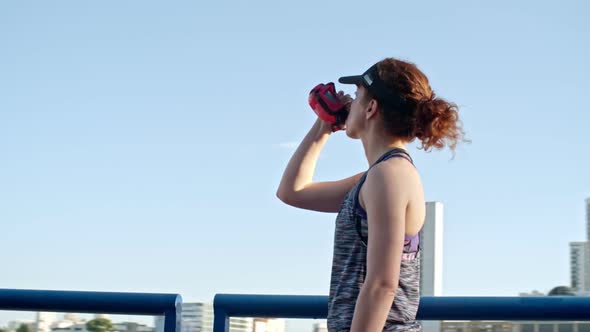 Female Athlete Drinking Water in Urban Setting