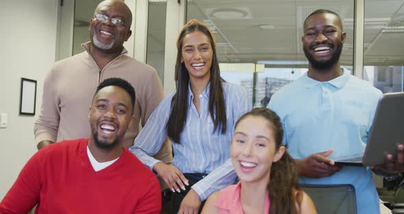 Portrait of diverse male and female business colleagues smiling in office