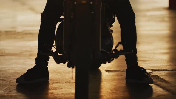 Tilt up of a man sitting on a motorcycle