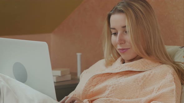 Full Length Side View of Female Patient Using Laptop on Bed in Hospital