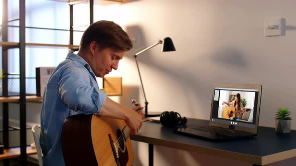 Man Learning To Play Guitar Online at Home