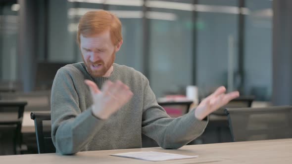 Upset Young Man Feeling Worried While Sitting in Office