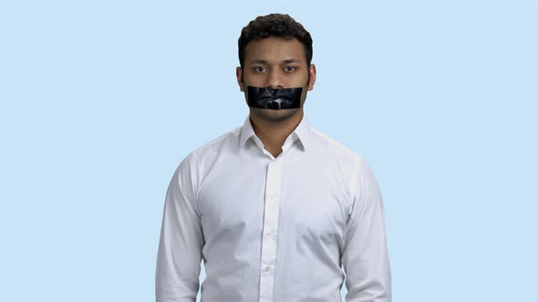 Portrait of Young Indian Man with Taped Mouth.