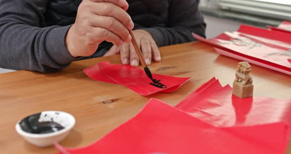 Man write chinese calligraphy for lunar new year