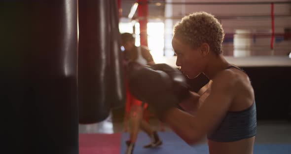 Mixed race women boxing in punchbag