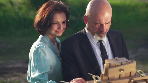 Concentrated Man and Smiling Woman Painting Outdoors in Slow Motion Looking at Each Other