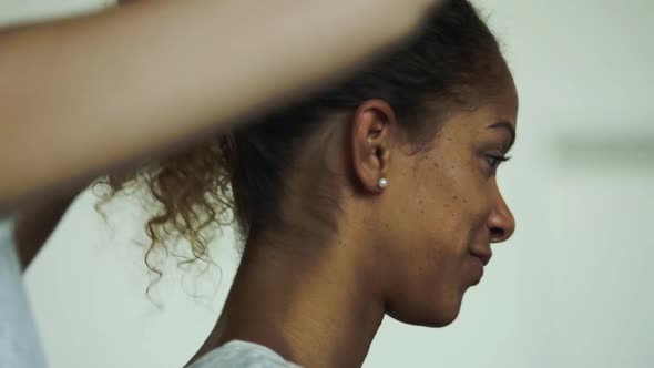 Hairdress tying womans hair up into ponytail