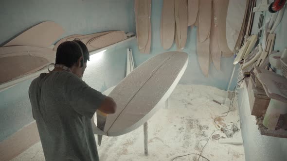 Indonesian Artisan Using Handsaw for Making Surfboard