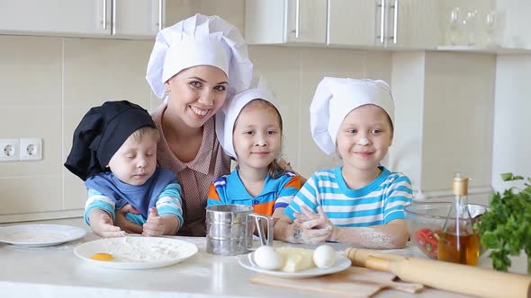 Portrait of Happy Family in Kitchen. Mom Teaches Kids To Cook
