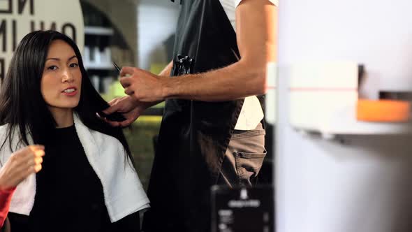 Male hairdresser styling a womans hair