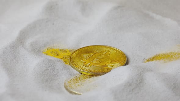 Bitcoin Cryptocurrency Gold Coins Fall on Dry White Sand