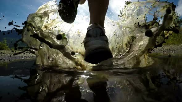 Rear view of fit woman jogging through puddle 4k