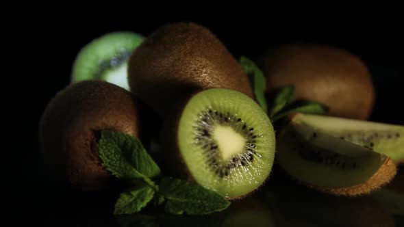 Delicious Juicy Fruit Kiwi and Mint Lie on a Black Table