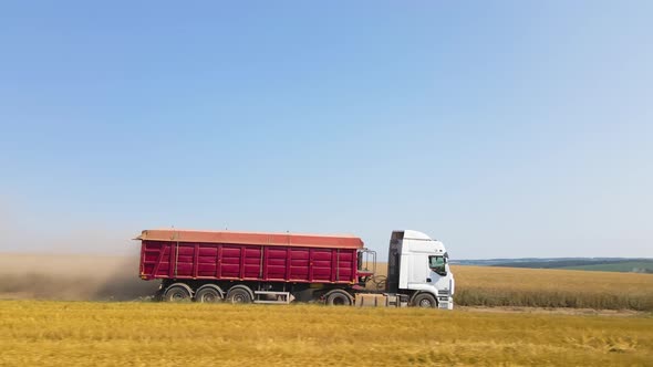 Aerial View of Lorry Cargo Truck Driving on Dirt Road Between Agricultural Wheat Fields