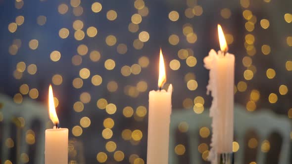 Close-up View of Burning Candles on a Background of Blurry Flickering Lights. Bright Beautiful