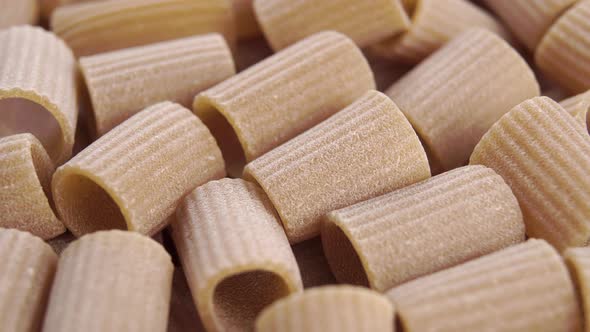 Dry uncooked Italian rigatoni pasta with a textured surface