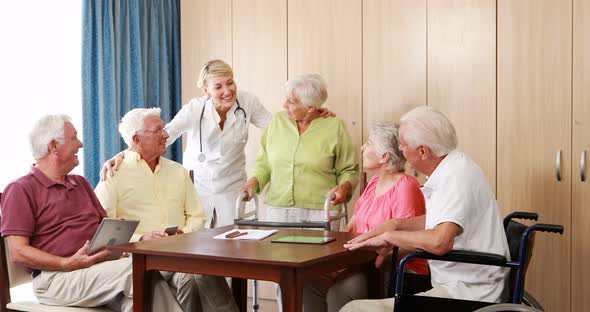 Female doctor interacting with senior citizens