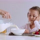 Sleepy girl is starting to eat her cornflakes with milk for breakfast. - VideoHive Item for Sale