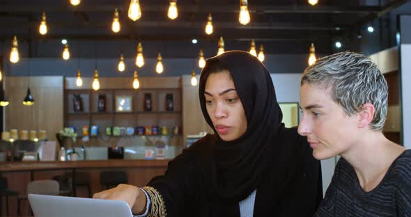 Female executives discussing over laptop 4k