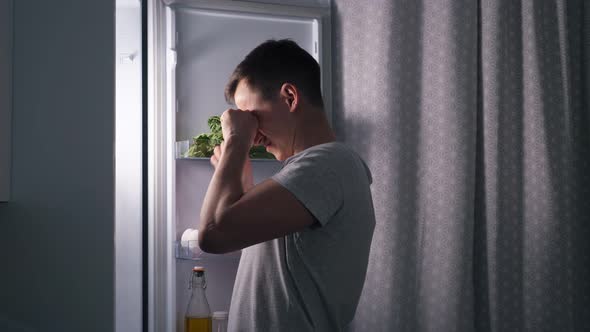 Hungry Husband Eats Delicious Cake Standing in Dark Kitchen