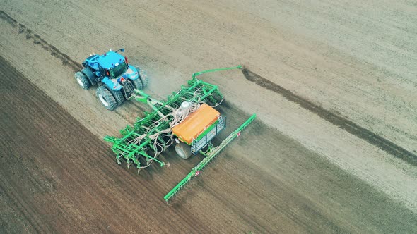 A Tractor Rides on a Field, Ploughing It for Sow.