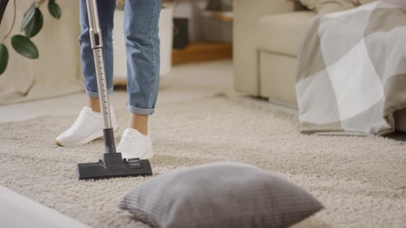 Legs of Woman Vacuuming in Apartment