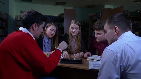 Group of Students Sitting at a Table in a Library, Camera Moves To the Right, Slow Motion