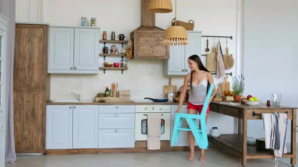 Cooking Girl Transforming Chair Into Ladder To Reach The Top Of Shelf