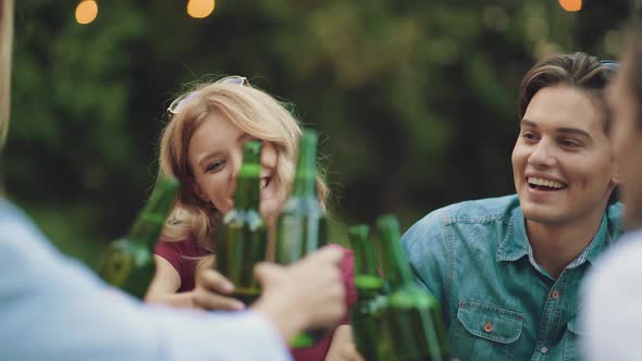 Friends Drinking Beer And Toasting At Outdoor Party