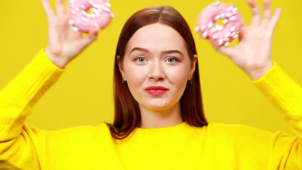 Closeup Headshot of Cheerful Smiling Young Woman Putting Pink Donuts on Eyes As Eyeglasses