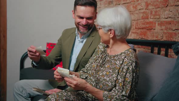 Medium Shot of a Handsome Caucasian Bearded Man in His 40s and His Elderly Pensioner Mother Looking