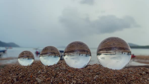 Four Crystal Balls On The Beach In The Rain.